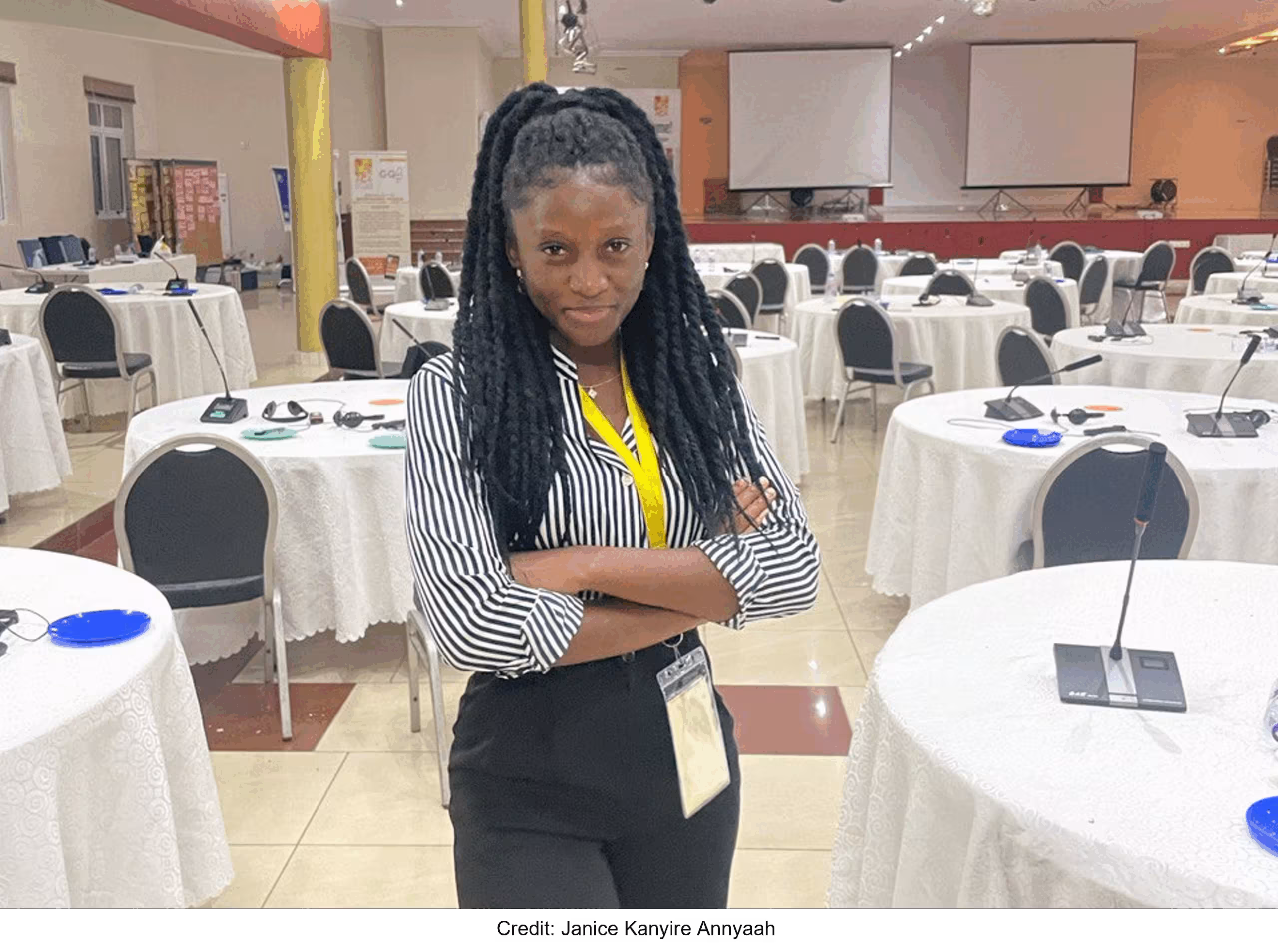 Janice Kanyire Annyaah standing in front of white tables, arms crossed